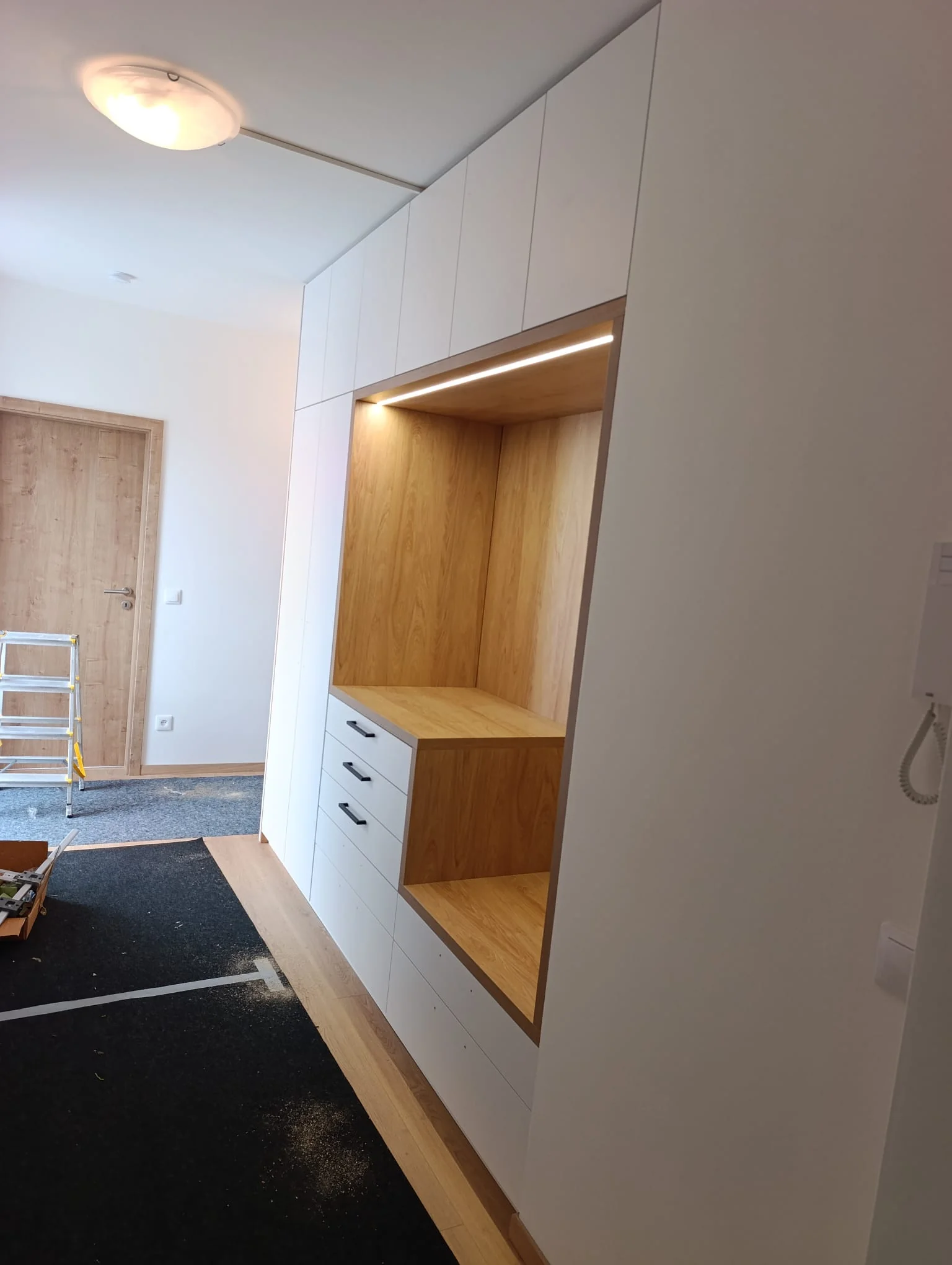 Bílá vestavěná skříň v předsíni s LED podsvícením