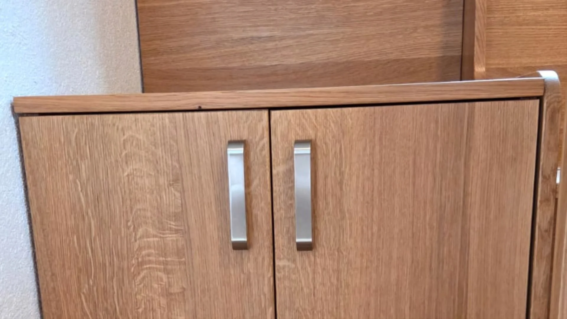 Detail dubových dvířek vestavěné skříňky s kovovými úchytkami